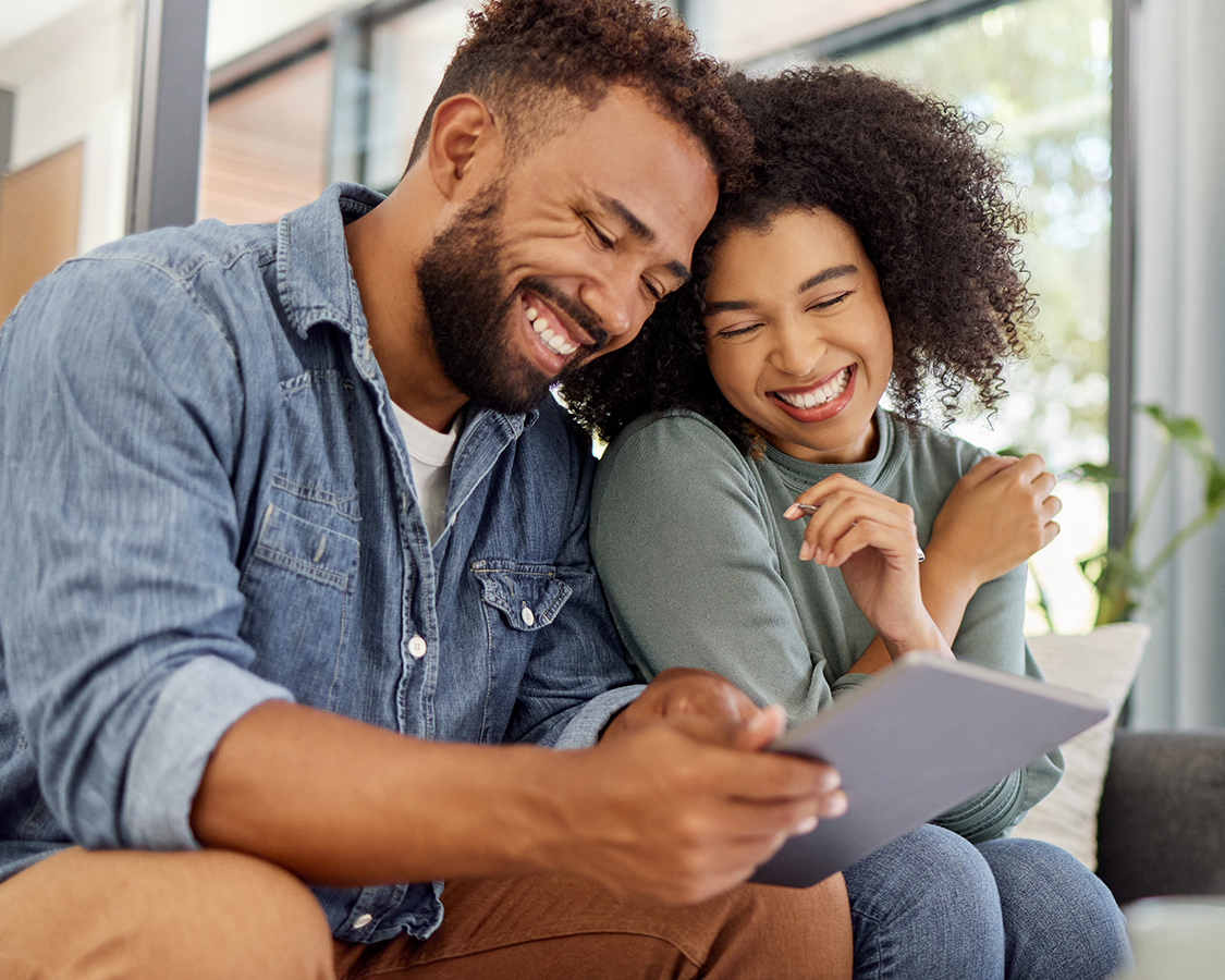 Happy couple looking at a tablet