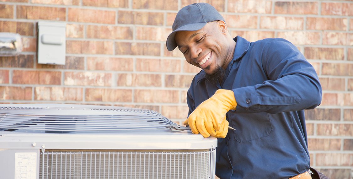 Happy technicians working on a HVAC unit